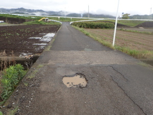 道路の舗装面が陥没している写真